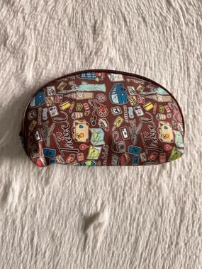 Brown make up/ pencil pouch travel-themed graphic featuring landmarks and icons